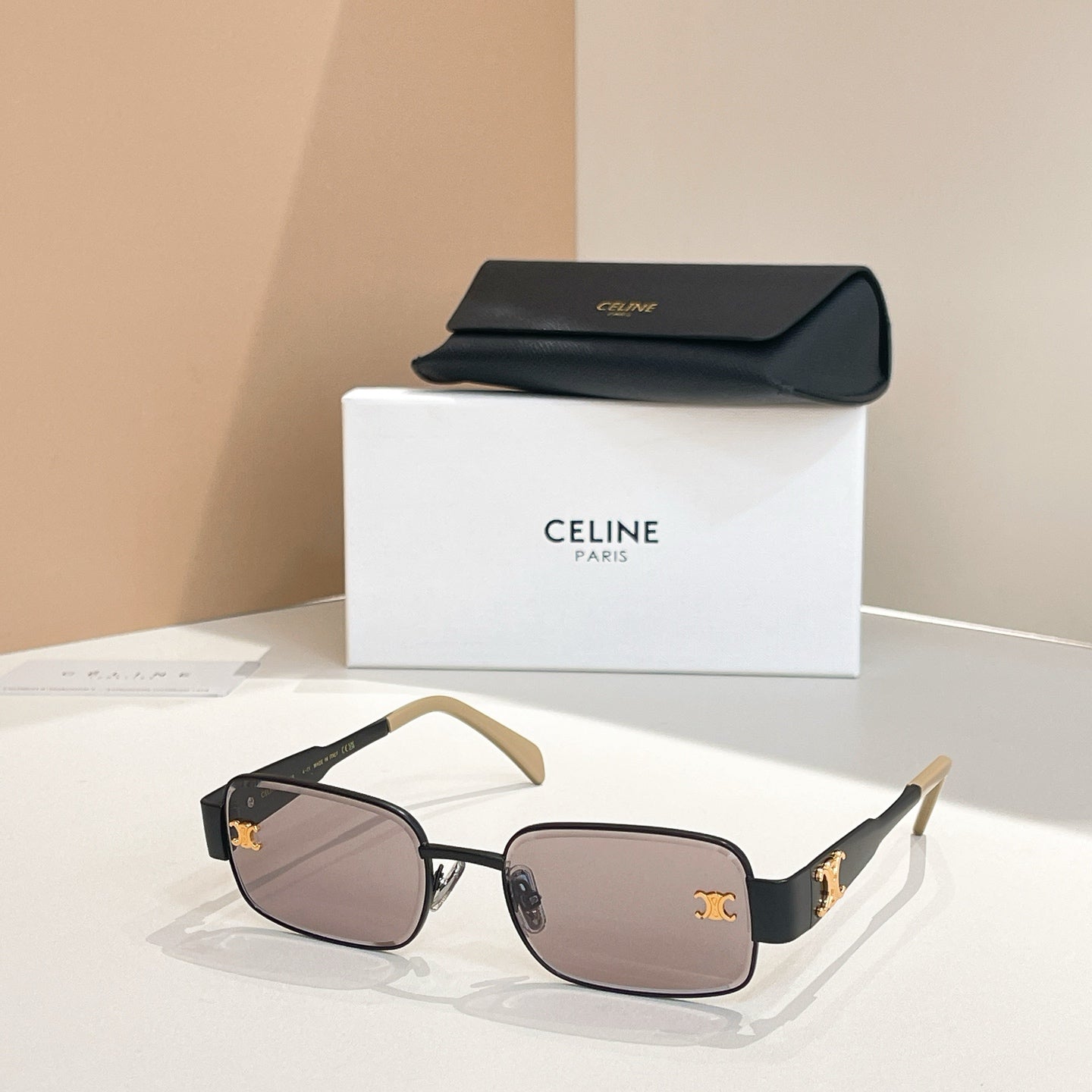 Dark-tinted square sunglasses with black frames and gold-tone arms