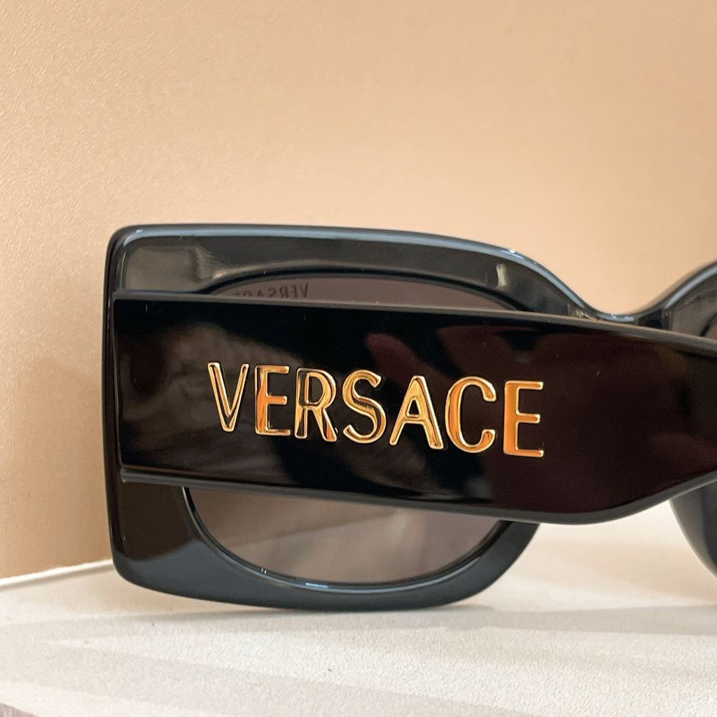Dark sunglasses temple with VERSACE lettering in gold