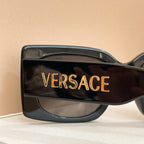 Dark sunglasses temple with VERSACE lettering in gold