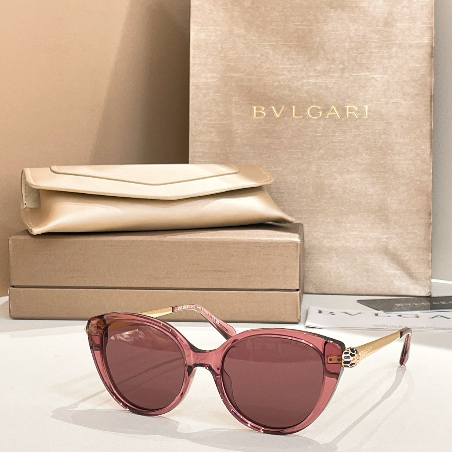 Pink round sunglasses with gold-tone temple detail and pink-tinted lenses