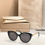 Black round sunglasses with gold-tone temple detail and dark lenses