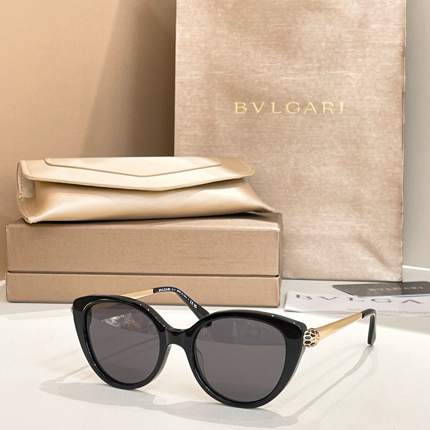 Black round sunglasses with gold-tone temple detail and dark lenses