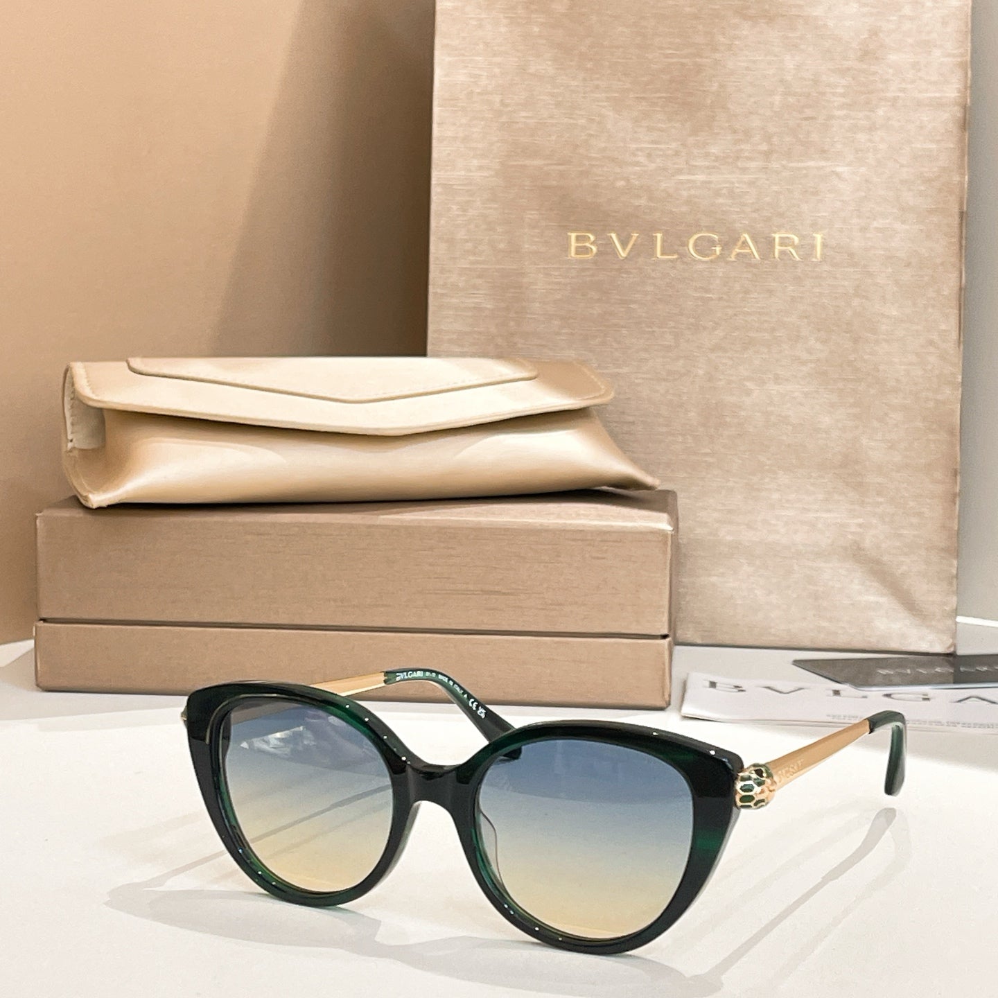 Dark green round sunglasses with gold-tone temple detail and blue-tinted lenses