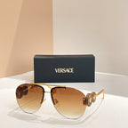 Versace sunglasses with gold frame and amber tinted lenses; logo detail on temple arms