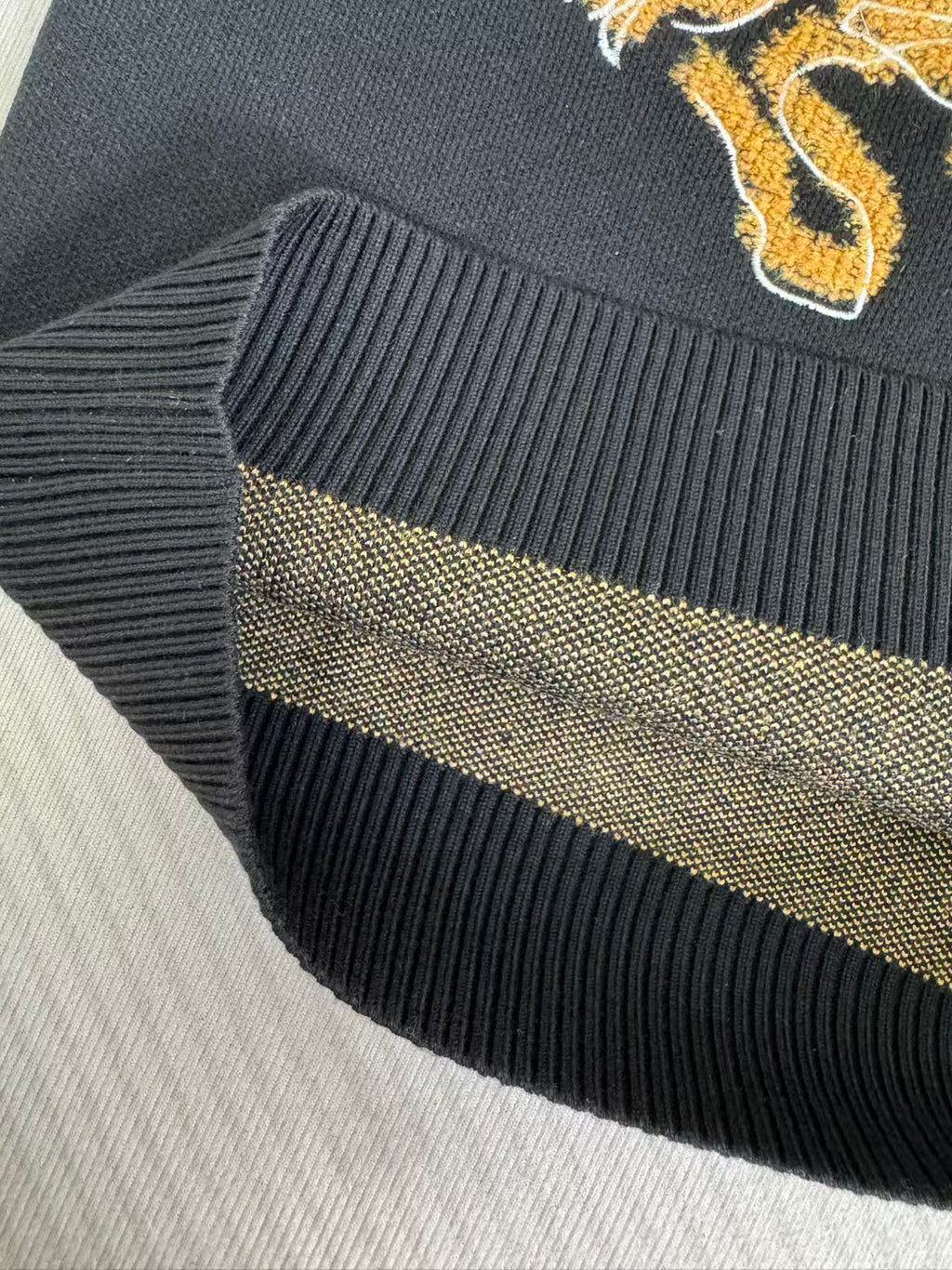 Navy sweater ribbed knit hem with gold logo stripe detail