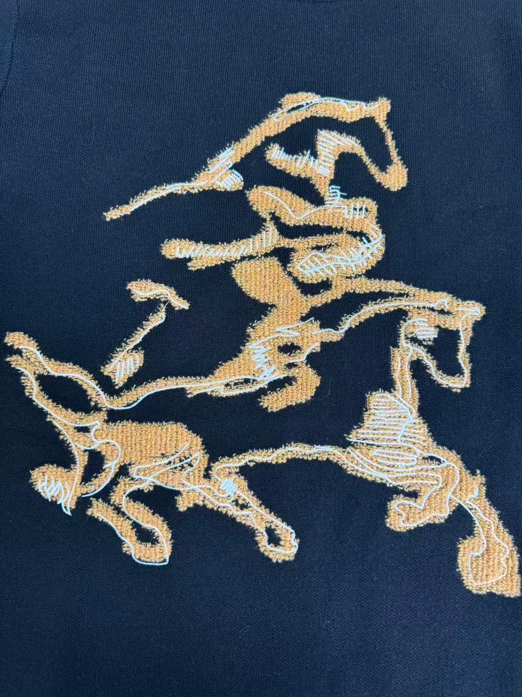Navy sweater front featuring gold horse crest embroidered graphic