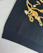 Navy sweater sleeve with gold horse crest embroidery detail