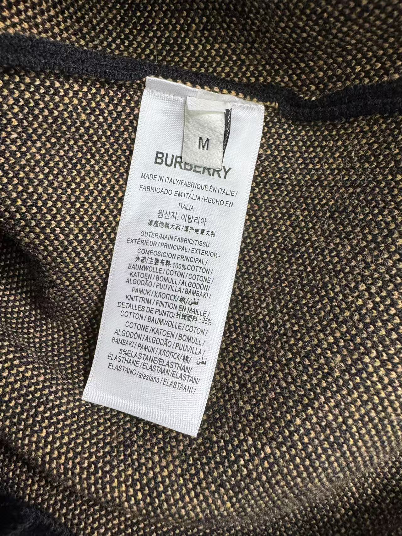 Fabric label on a dark knit sweater showing Burberry and size M