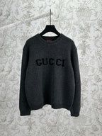 Gucci dark charcoal knit sweater with GUCCI logo on front