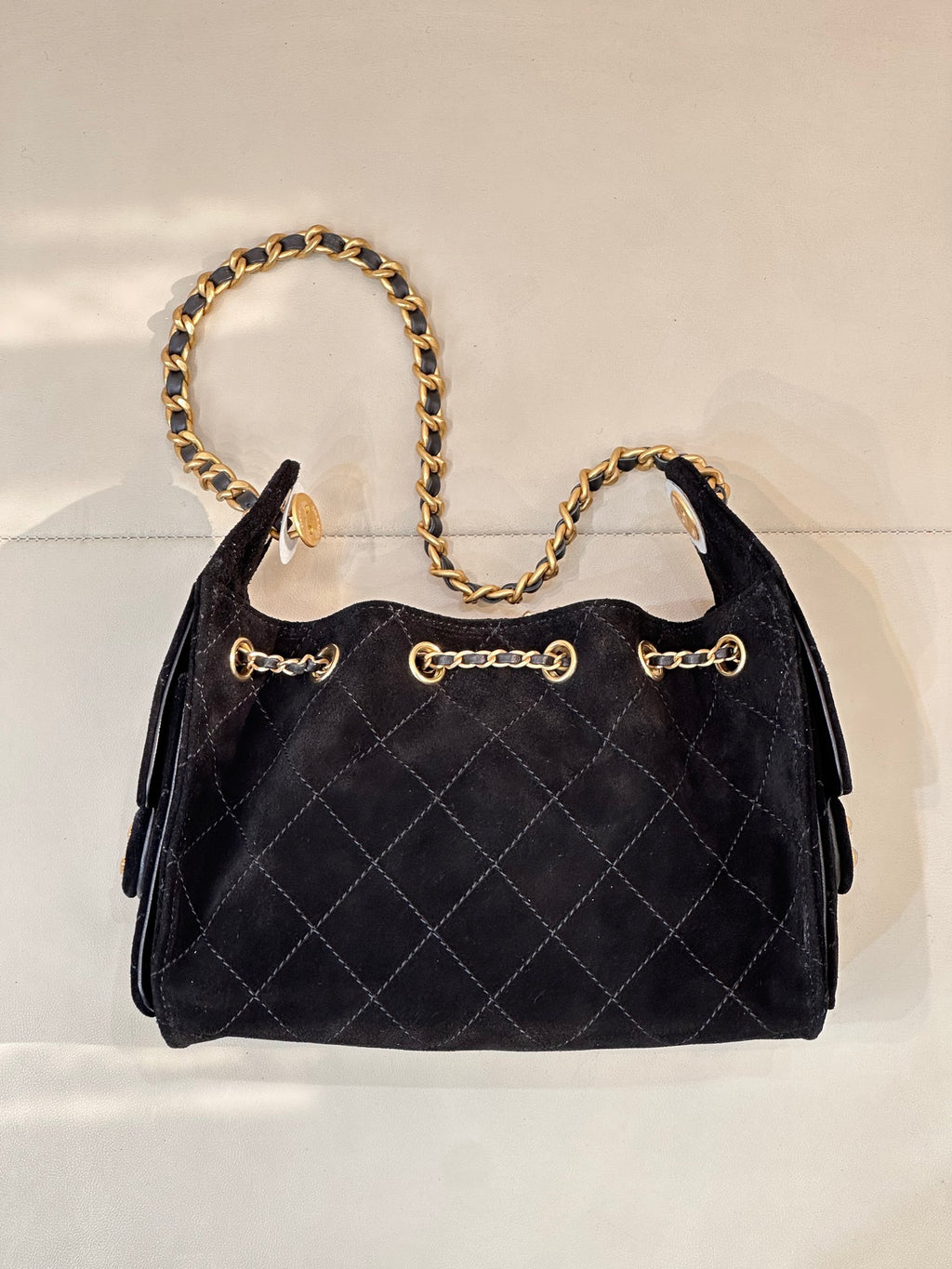 Chanel quilted handbag front view with gold chain strap and decorative front rings, black