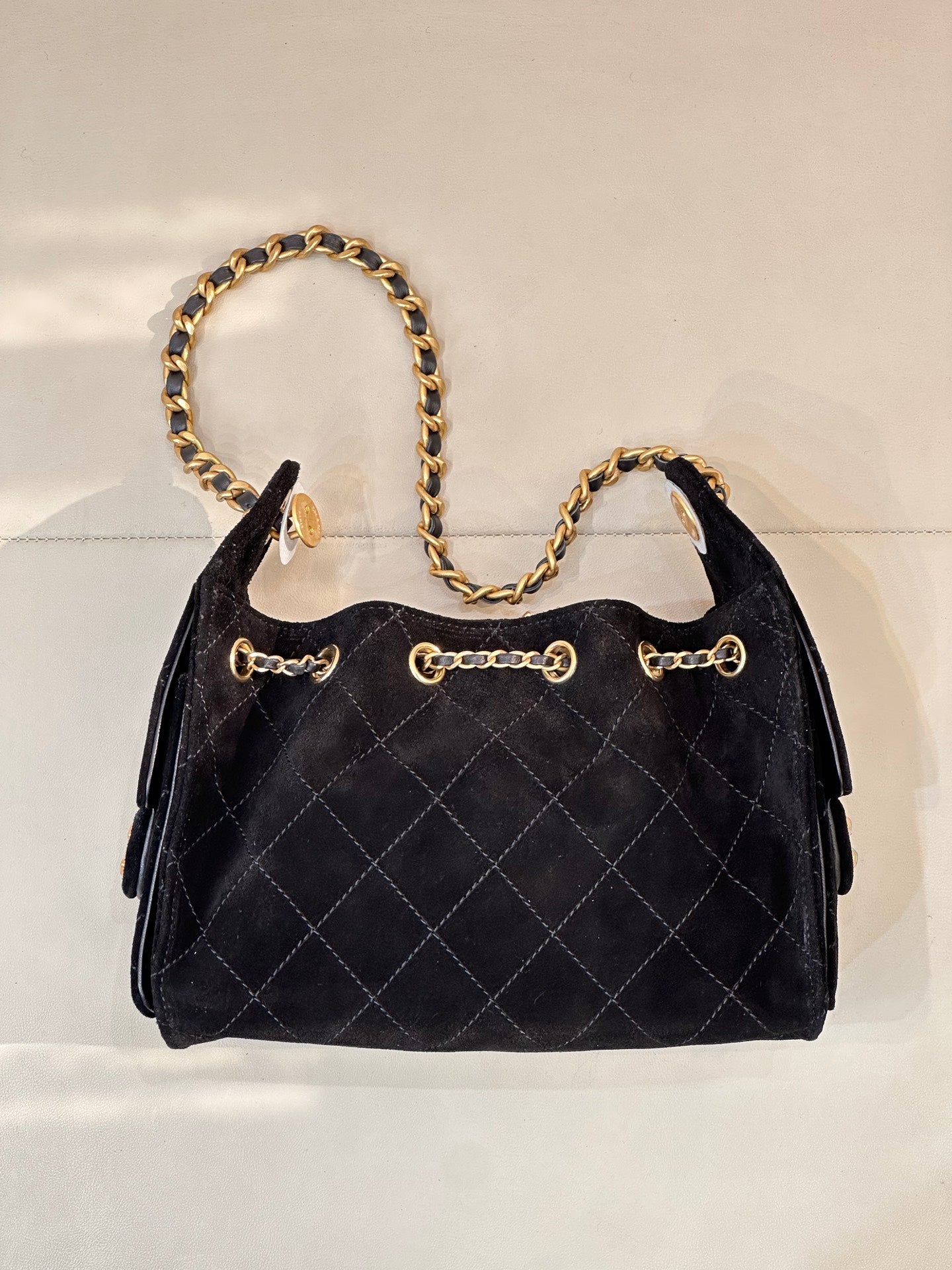 Chanel quilted handbag front view with gold chain strap and decorative front rings, black