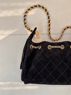 Chanel quilted handbag corner view with gold chain strap and flap hardware, black