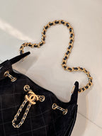 Chanel quilted handbag detail view with gold chain handle and clasp hardware, black