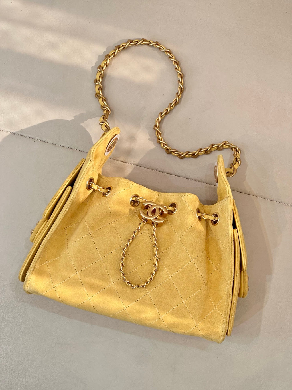 Chanel yellow quilted bucket handbag with gold chain strap and drawstring ties