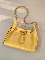 Chanel yellow quilted bucket handbag with gold chain strap and drawstring ties
