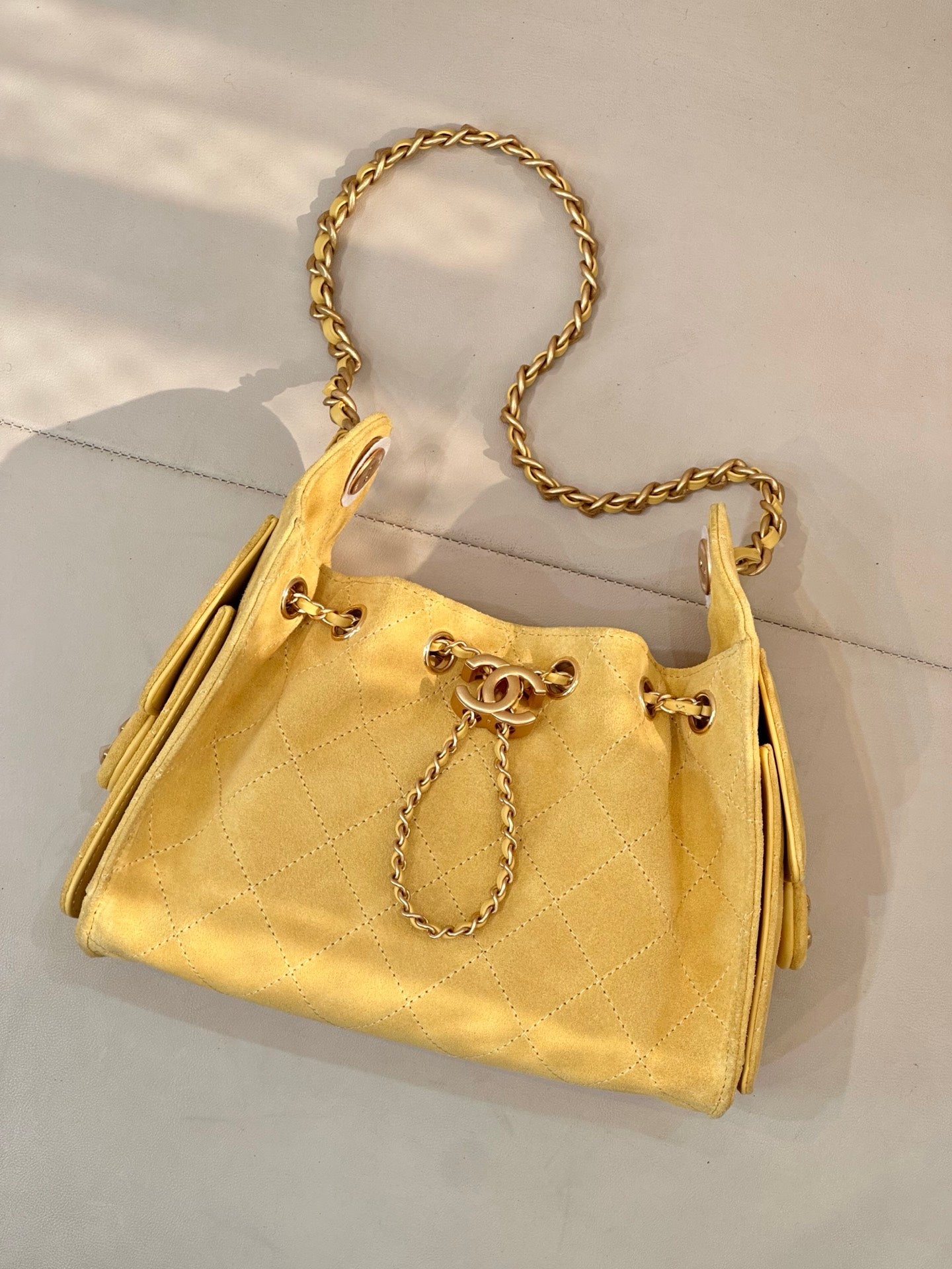 Chanel yellow quilted bucket handbag with gold chain strap and drawstring ties