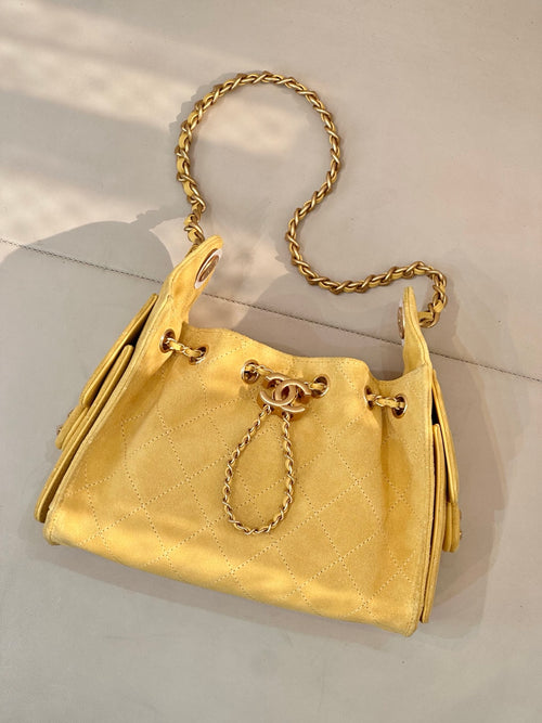 Chanel yellow quilted bucket handbag with gold chain strap and drawstring ties