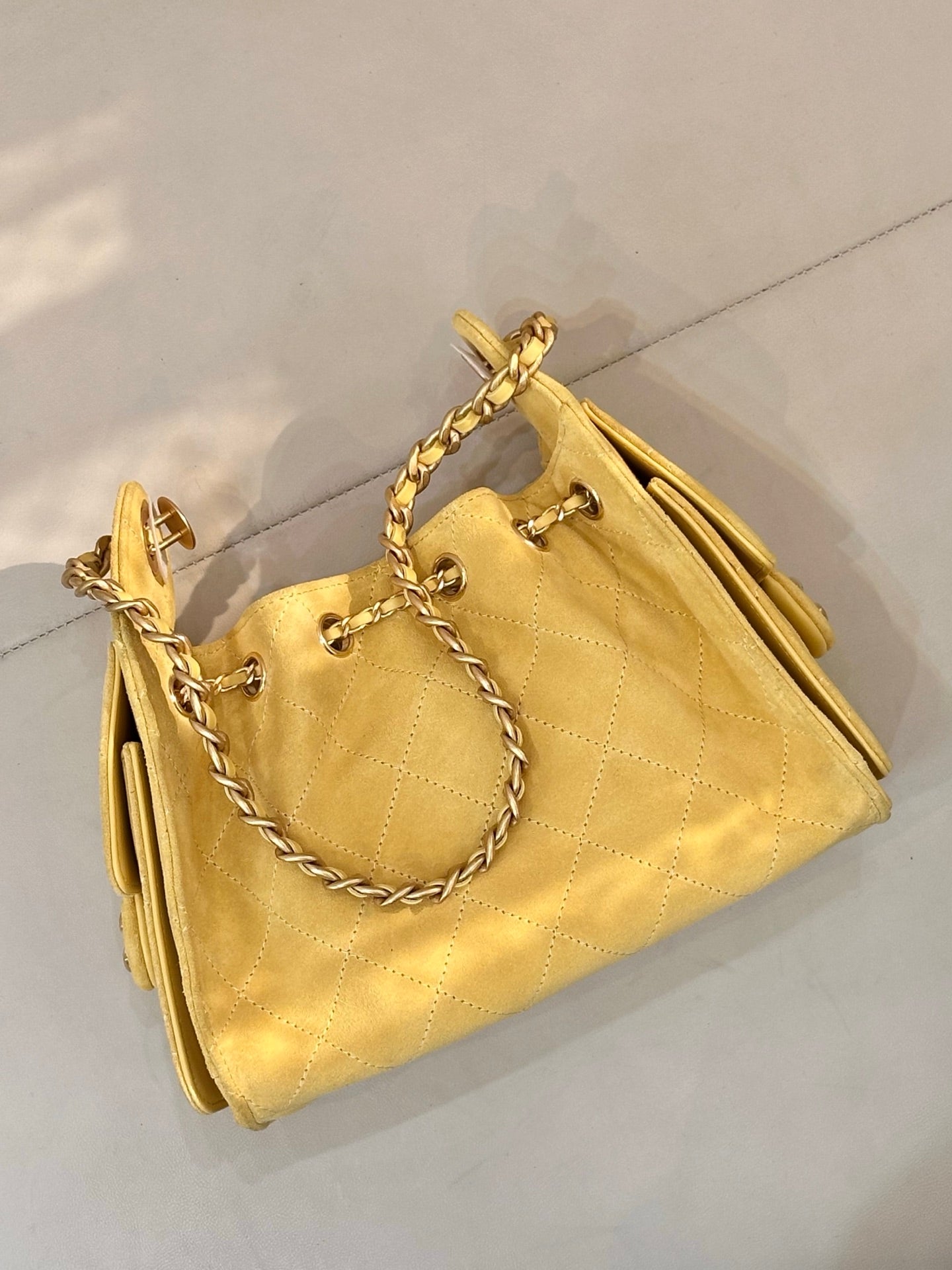 Chanel yellow quilted bucket handbag with chain handles and side hardware