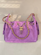 Purple quilted Chanel handbag with braided chain handles and gold CC front plaque