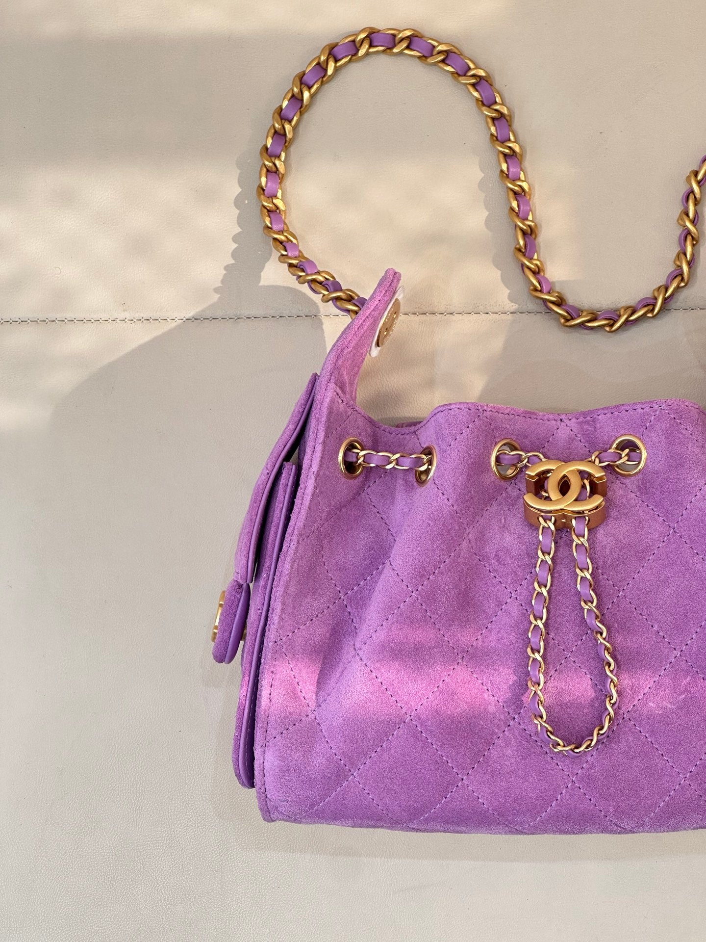 Purple quilted Chanel handbag with front CC charm and braided chain shoulder strap