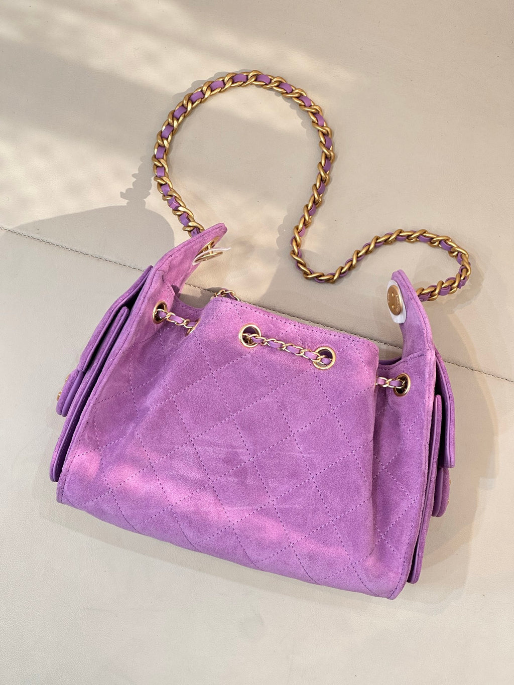 Purple quilted Chanel handbag with braided chain strap and front gold ring hardware