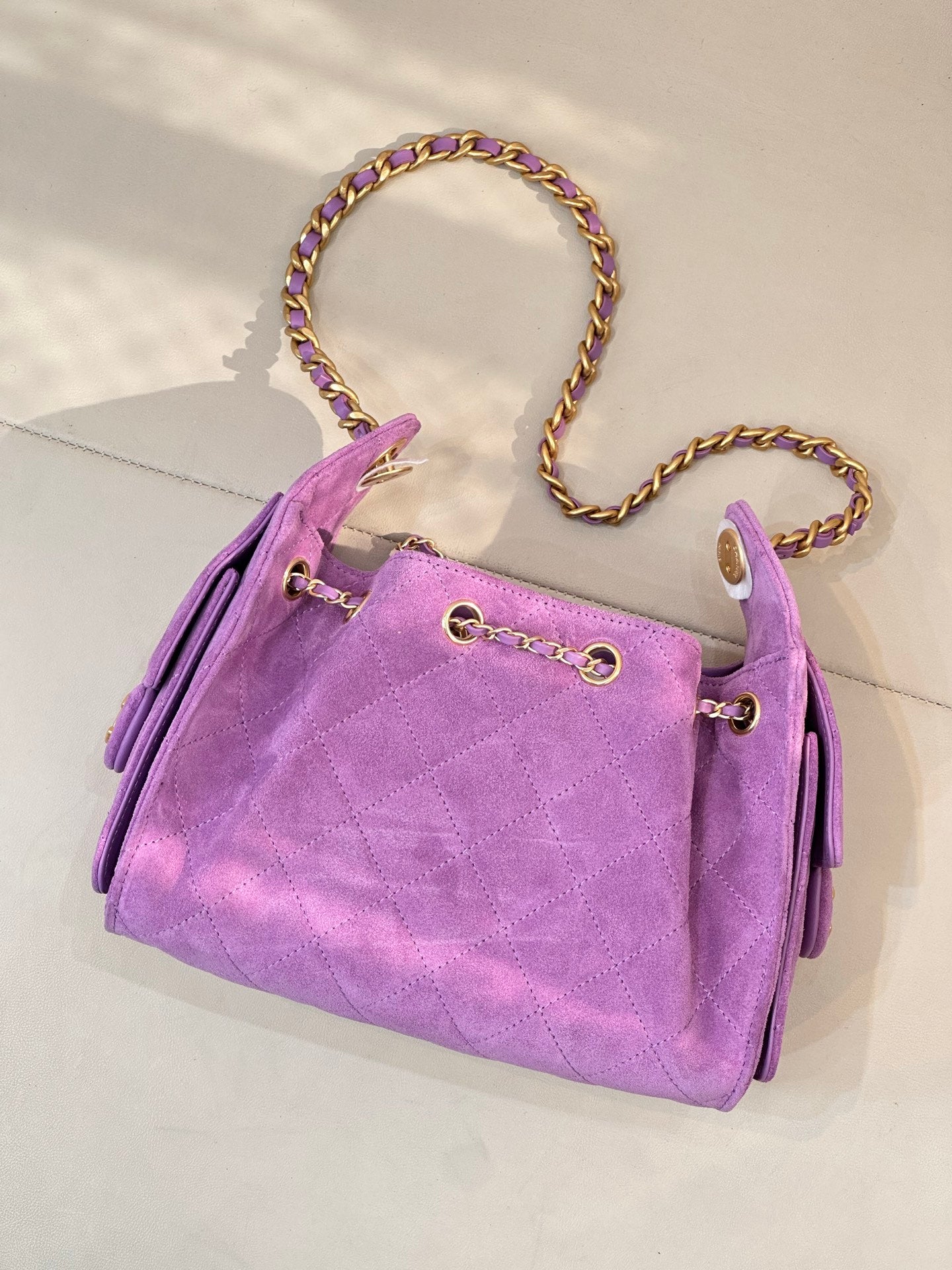 Purple quilted Chanel handbag with braided chain strap and front gold ring hardware