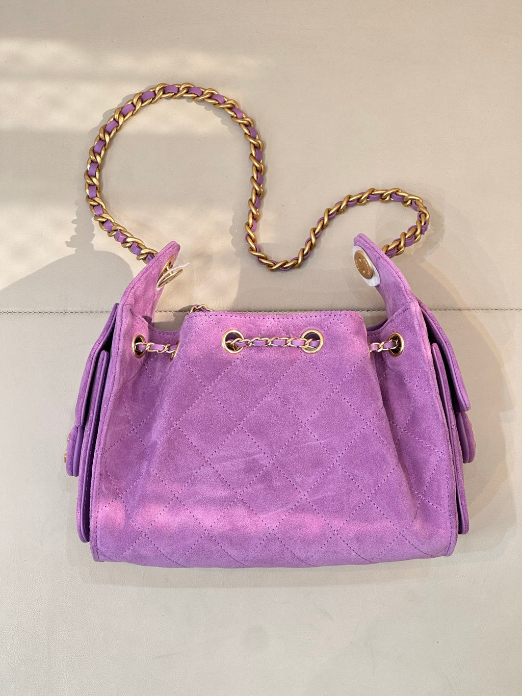 Purple quilted Chanel handbag with braided chain strap and zipper-pull details