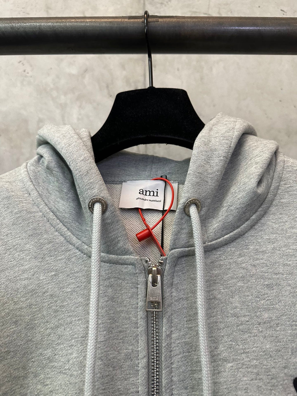 Light gray zip-up hoodie with hood drawstrings and front zipper pull