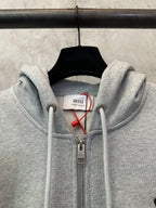 Light gray zip-up hoodie with hood drawstrings and front zipper pull