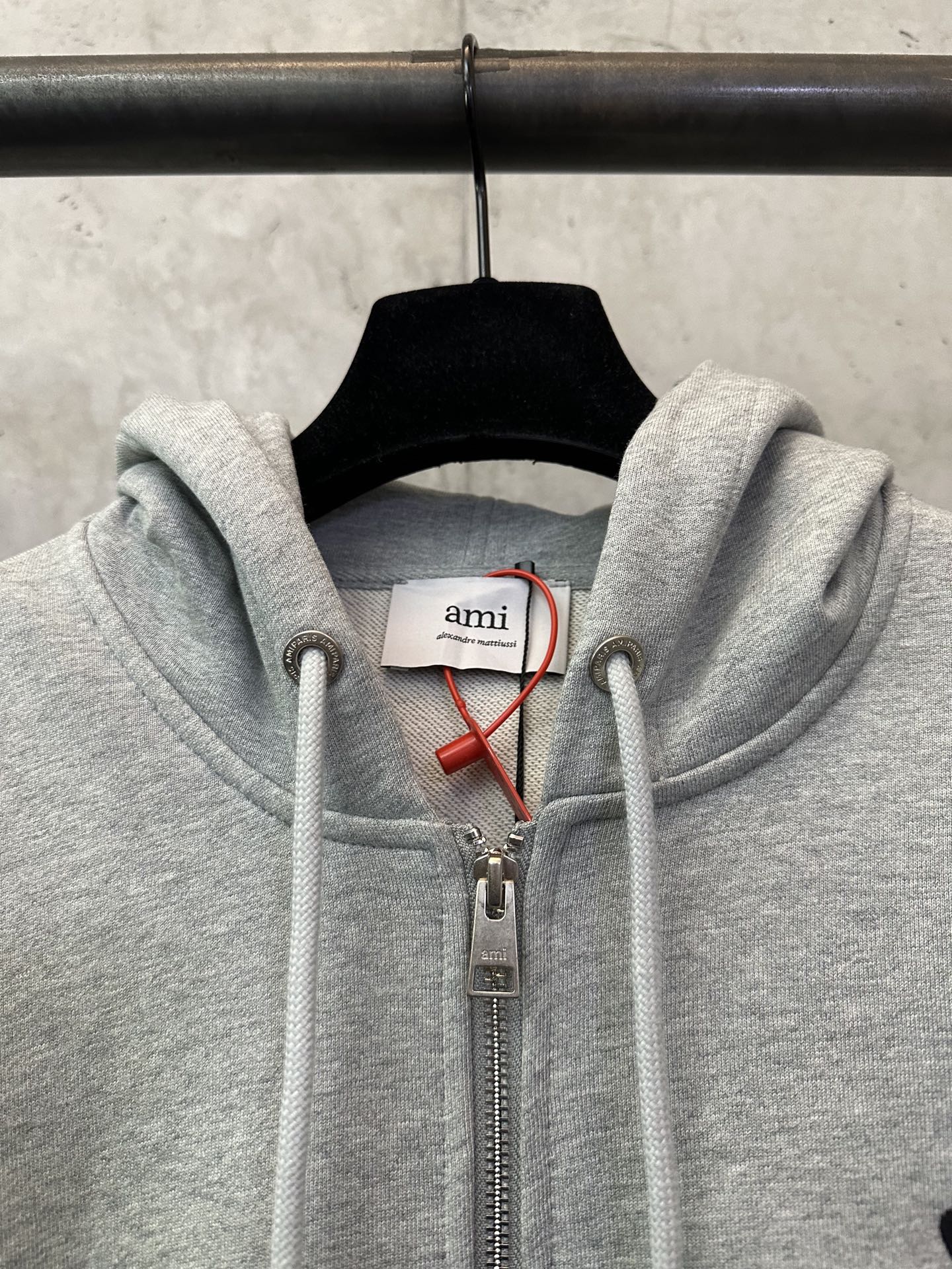 Light gray zip-up hoodie with hood drawstrings and front zipper pull