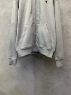 Light gray zip-up hoodie close view of front zipper and kangaroo pocket