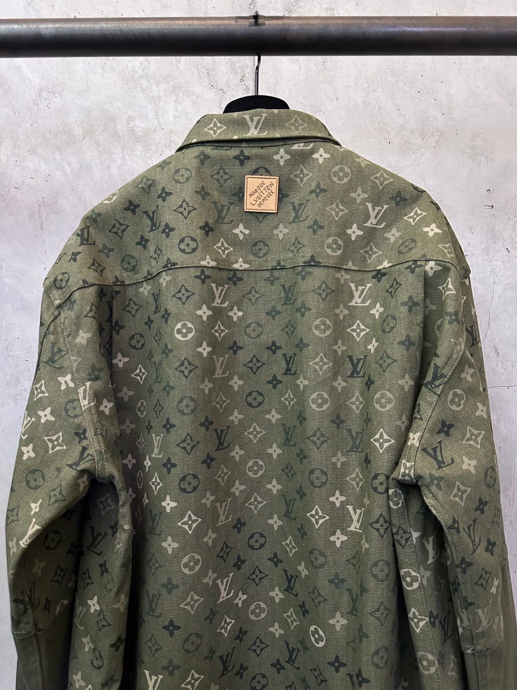 Olive green monogram button-up jacket, back view with brand patch at collar.