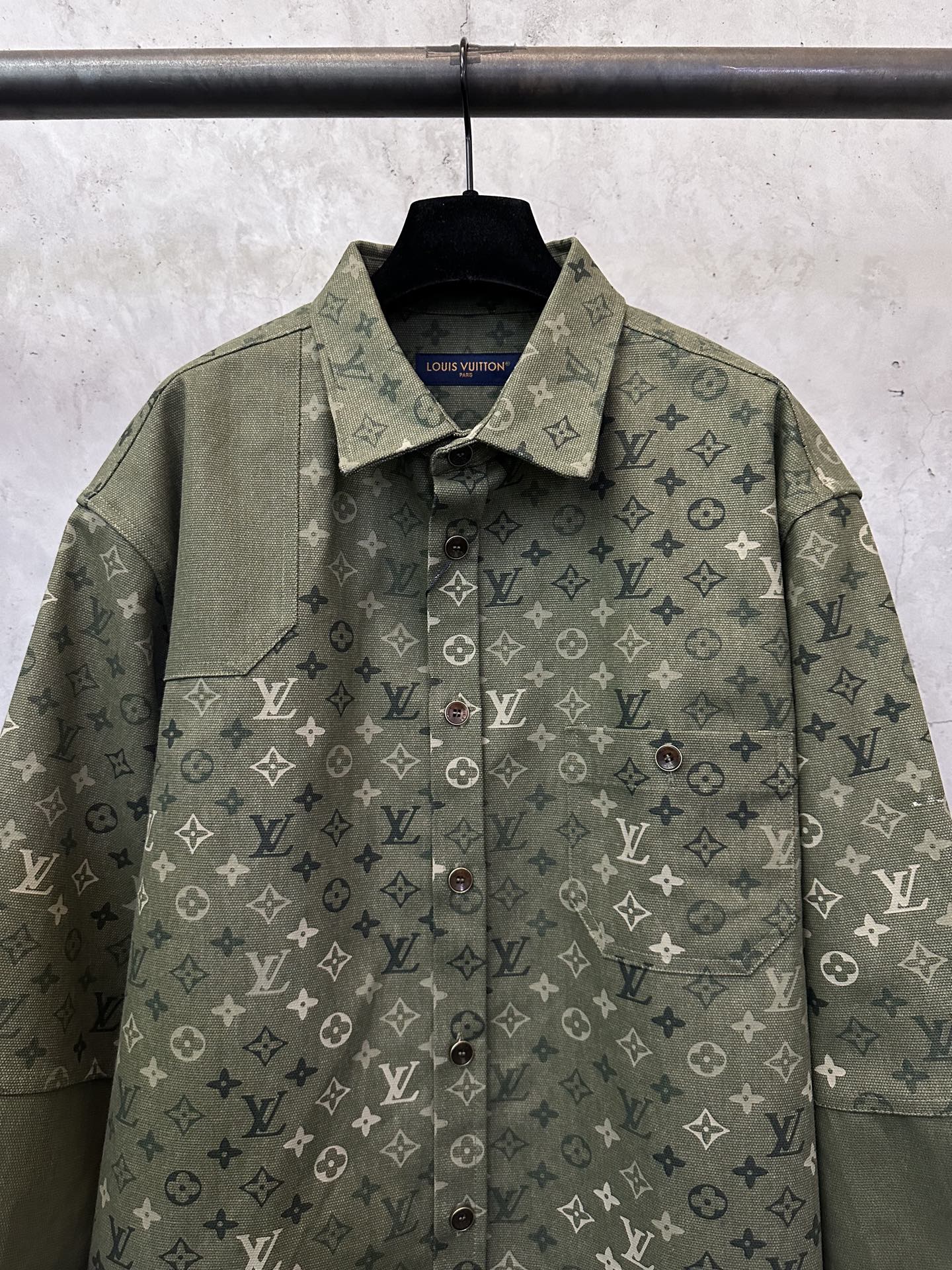 Olive green monogram button-up jacket, point collar and front button placket.