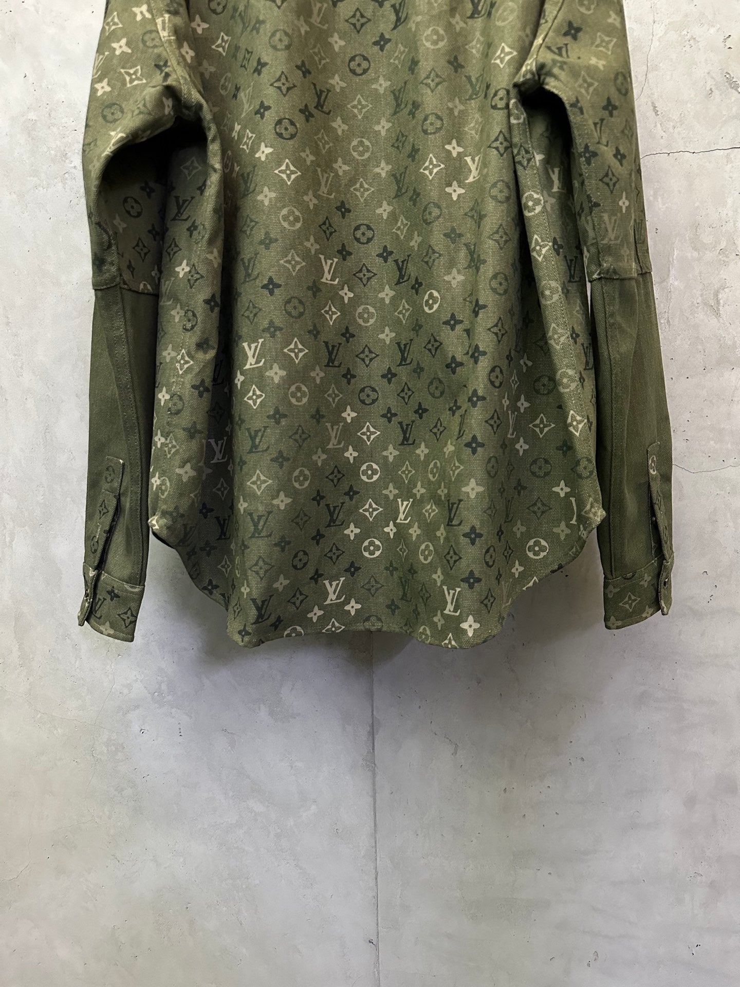 Olive green monogram long-sleeve jacket, back hem and sleeve openings visible.