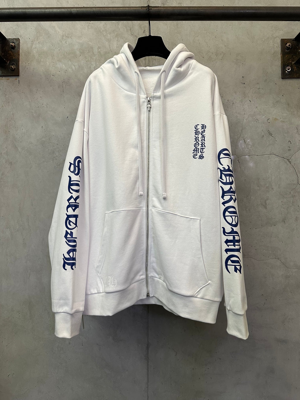 White zip-up hoodie with blue sleeve graphic, front kangaroo pocket, drawstrings