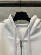 White zip-up hoodie close-up of zipper and hood drawstrings