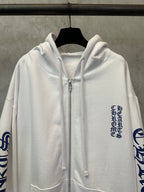 White zip-up hoodie close-up with silver zipper and chest logo text print