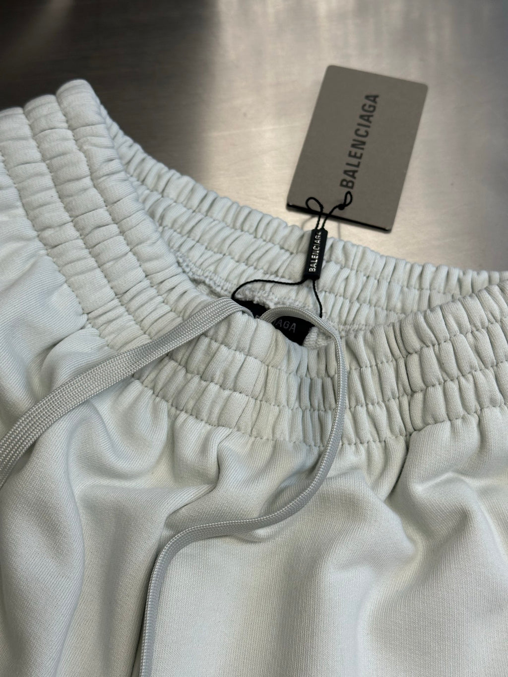 Balenciaga white pants with elastic waistband and gray drawstring cord