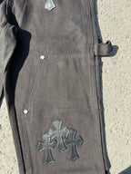 Black cargo pants leg close-up with cross patch and side pocket button