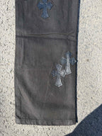 Chrome pants in dark gray with embroidered cross patches near the thigh and knee