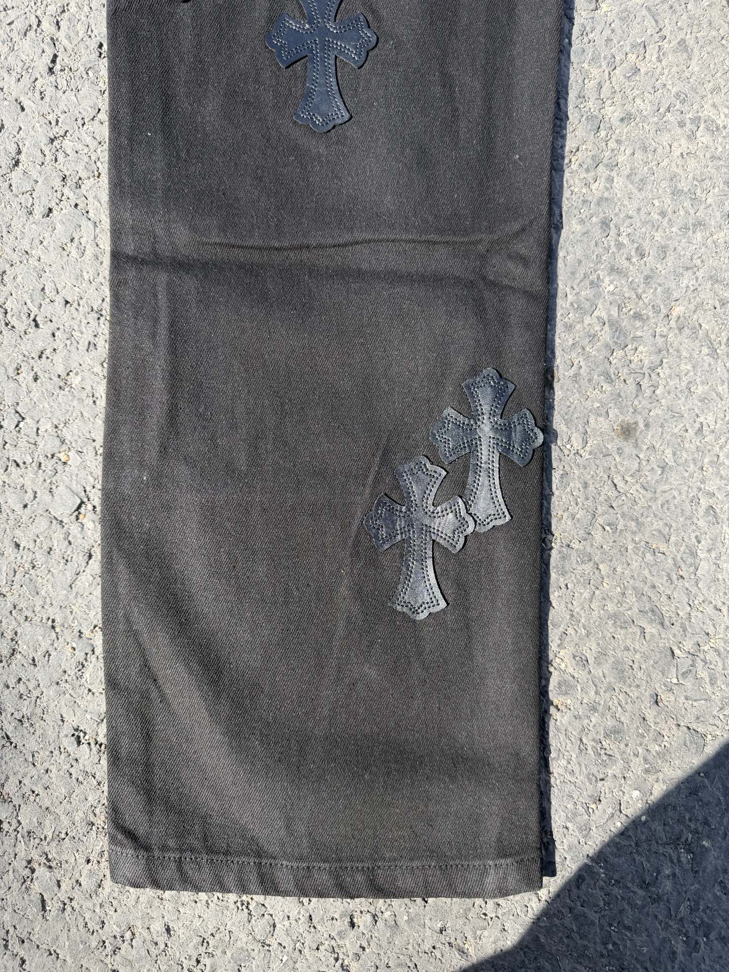 Chrome pants in dark gray with embroidered cross patches near the thigh and knee