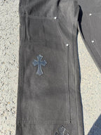 Black cargo pants side view with cross patch on leg and stitched seams
