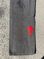 Dark gray jeans pants with red cross patch near hem