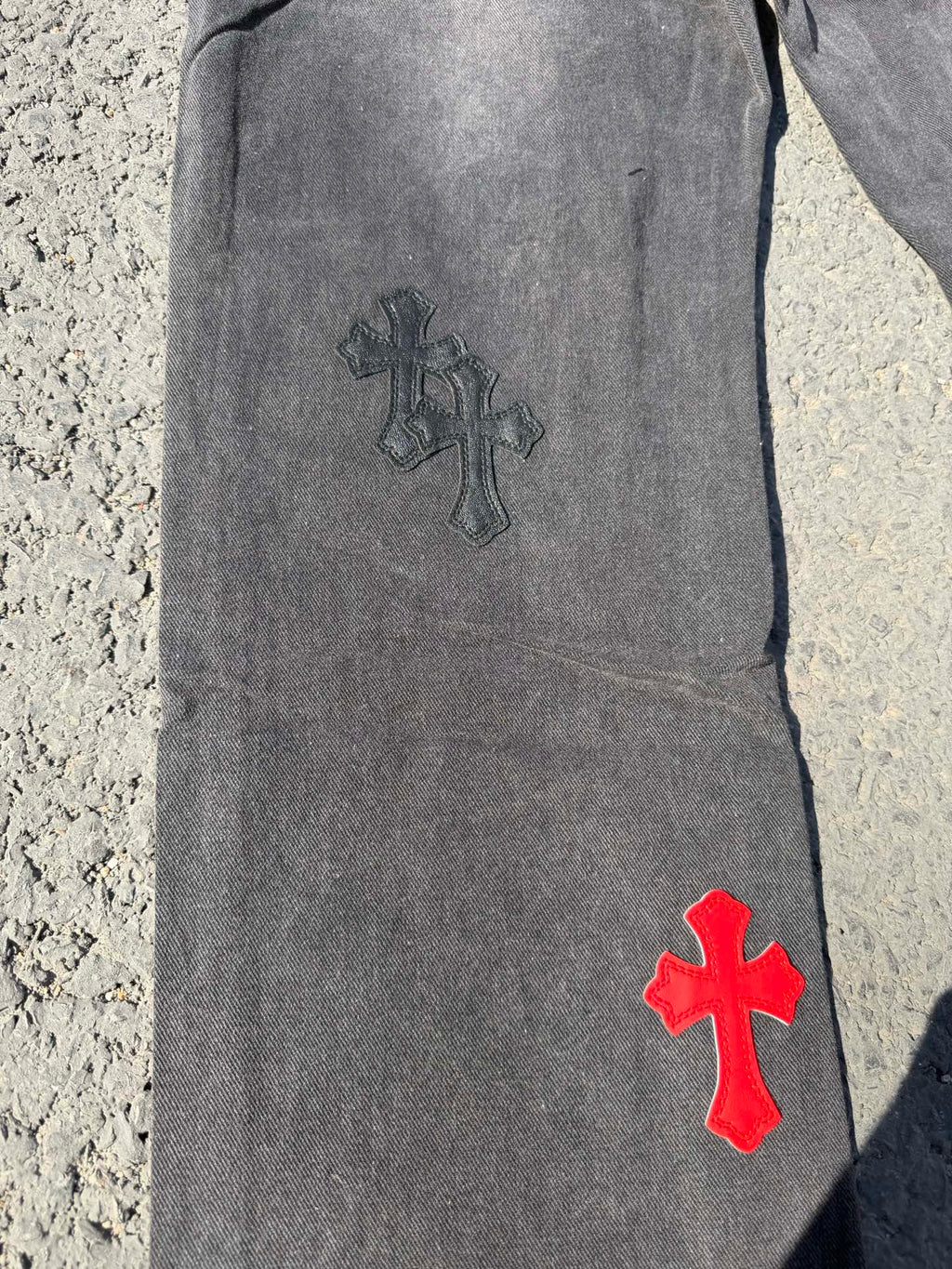 Dark gray jeans pants with dark and red cross patches on leg