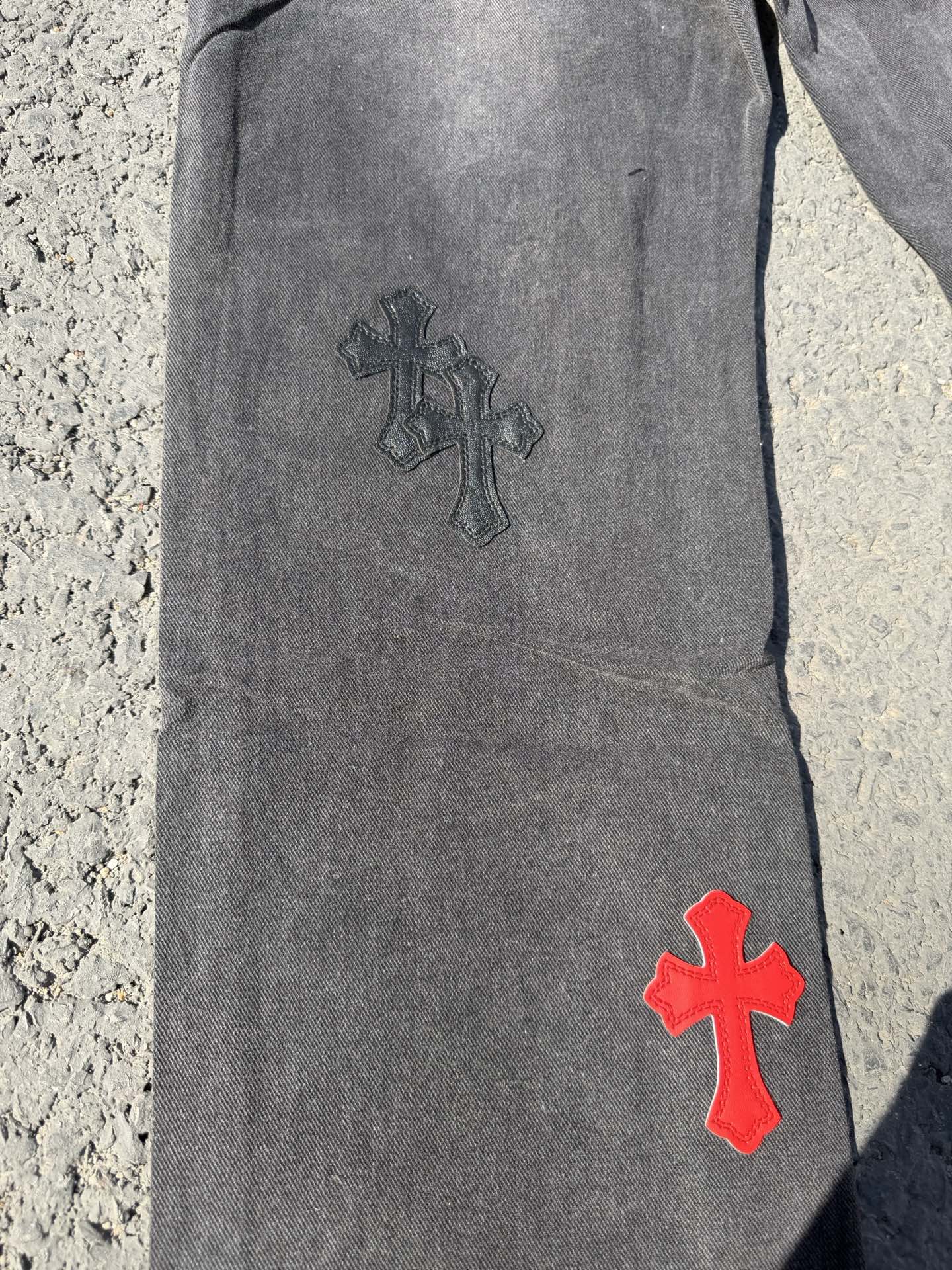 Dark gray jeans pants with dark and red cross patches on leg
