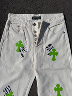 White denim pants with front button placket and green cross patches with black accents