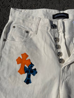 White cross-print pants close-up of button fly, coin buttons, and orange/blue graphic