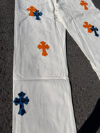 White pants with orange and blue cross graphics across the front leg