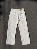 White denim pants with button fly and small chest embroidery on the leg