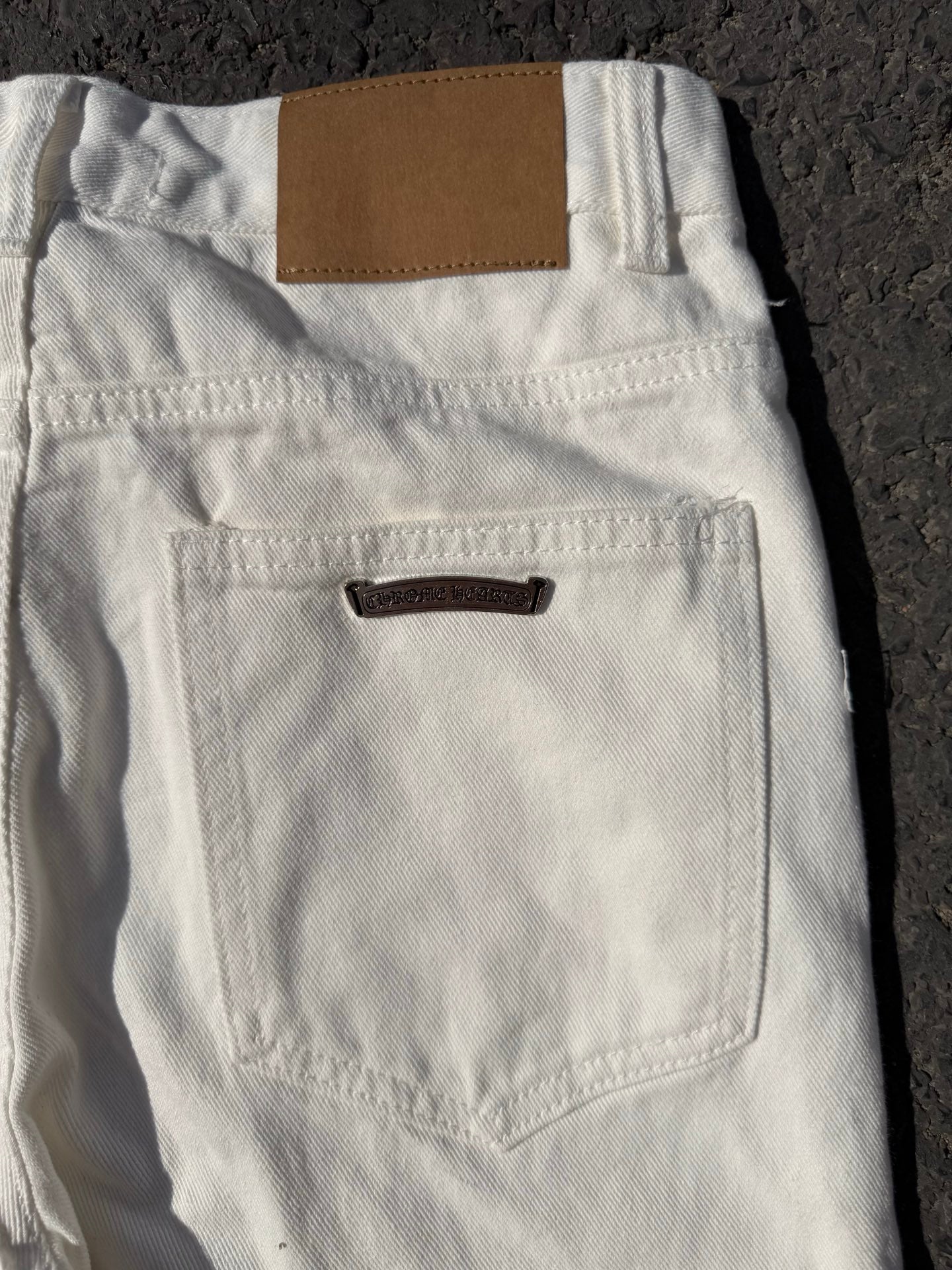 White denim pants with back patch pocket, belt loops, and dark label tab